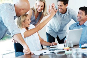 Portrait of an excited businesspeople giving each other high five for successful business at office