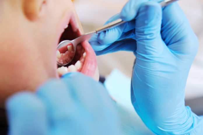 Un niño es atendido en la consulta de un dentista.