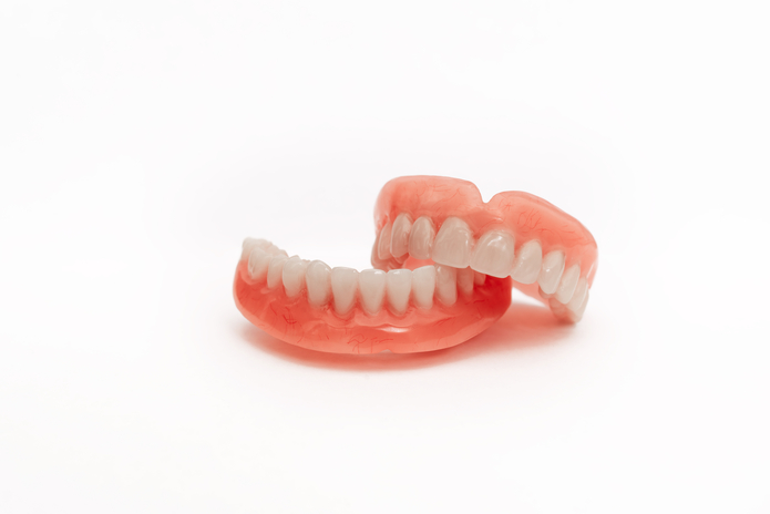 Resistencia adhesiva al cizallamiento de los dientes acrílicos adheridos a diferentes materiales de base para dentaduras postizas de alto impacto. 